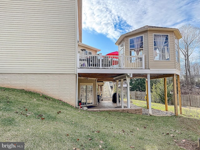 rear view of property featuring a yard, a deck, and a patio area