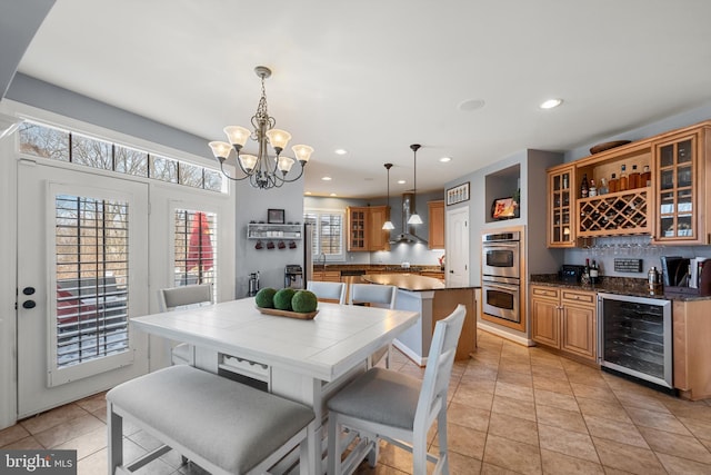 dining space featuring wine cooler, light tile patterned floors, an inviting chandelier, and indoor bar