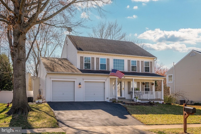 view of front of home featuring a porch, an attached garage, a front lawn, and aphalt driveway