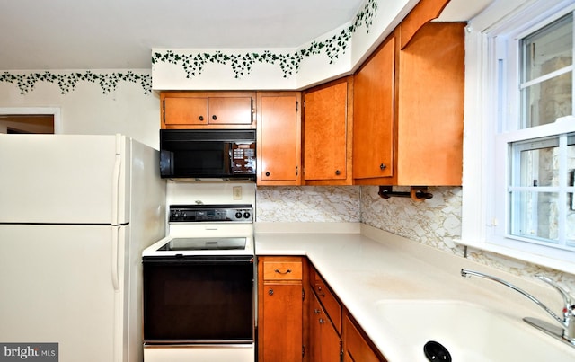 kitchen with sink, decorative backsplash, and black appliances