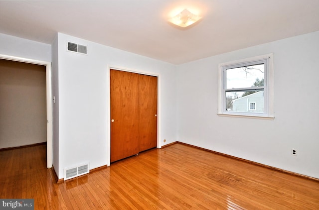 unfurnished bedroom with light hardwood / wood-style floors and a closet