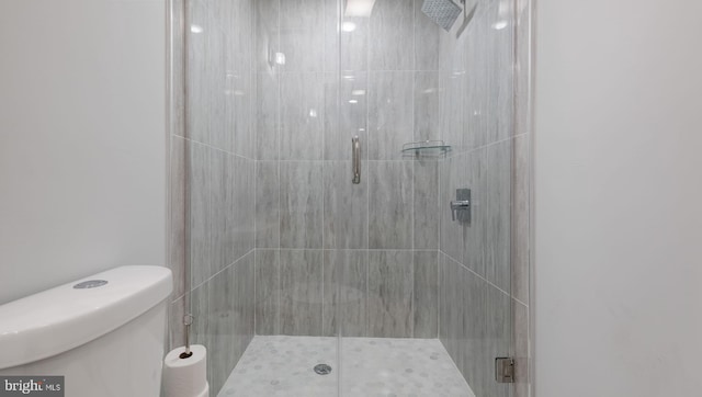 bathroom featuring toilet and an enclosed shower