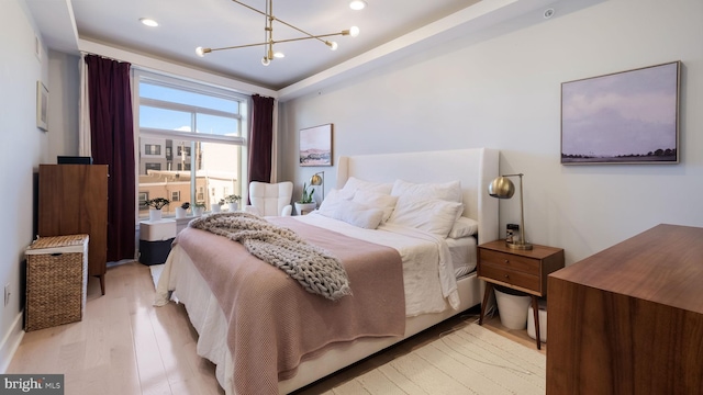 bedroom with an inviting chandelier and light hardwood / wood-style flooring