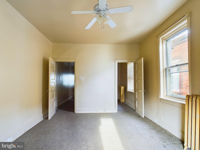 unfurnished bedroom with carpet flooring, radiator heating unit, and ceiling fan