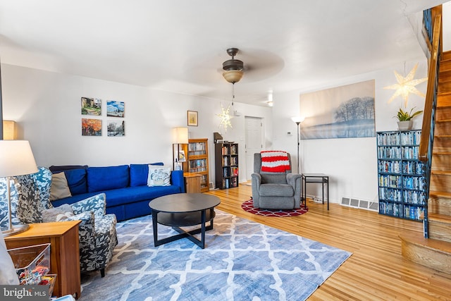 living room featuring visible vents, ceiling fan, and wood finished floors