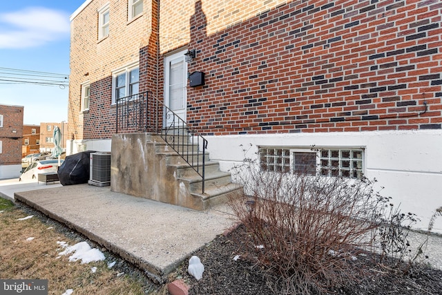 view of side of property with brick siding and central air condition unit