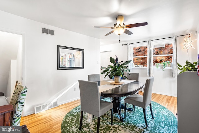 dining area with a ceiling fan, visible vents, baseboards, and wood finished floors