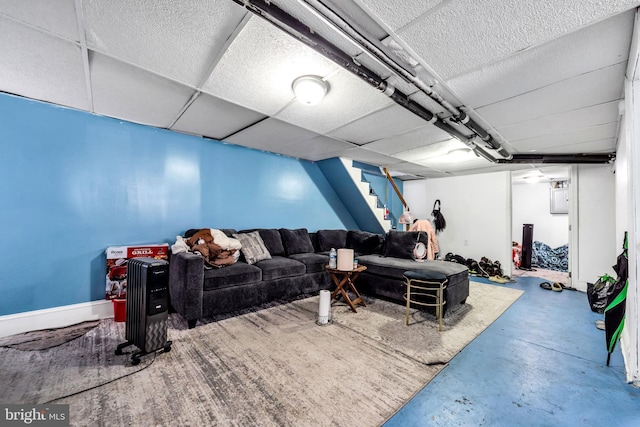 living room featuring concrete flooring and a drop ceiling