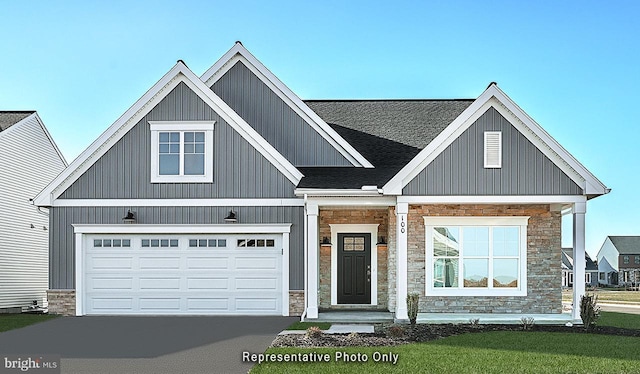 view of front of property with a garage, stone siding, driveway, roof with shingles, and board and batten siding