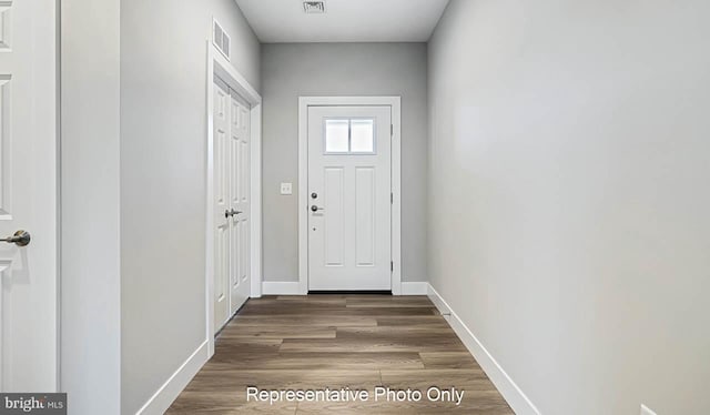 doorway to outside with dark wood-style flooring, visible vents, and baseboards