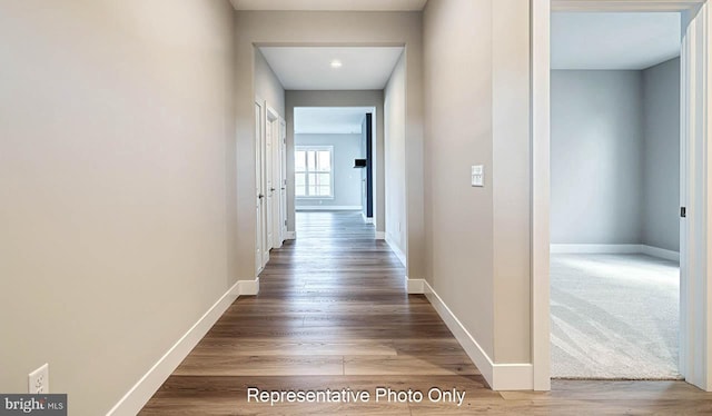 hallway featuring baseboards and wood finished floors