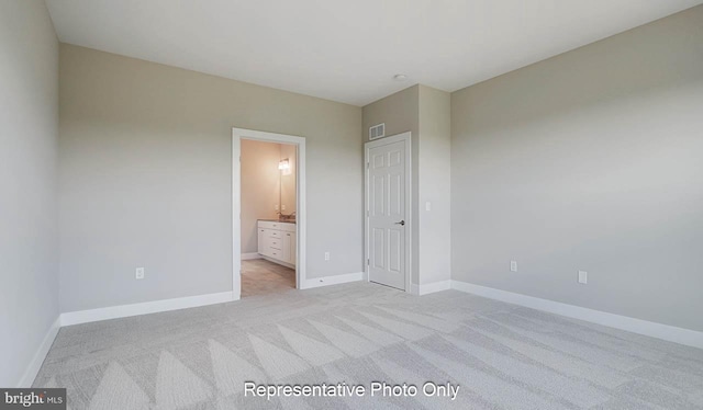 unfurnished bedroom with visible vents, baseboards, connected bathroom, and light colored carpet