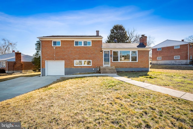 split level home with a front lawn, brick siding, concrete driveway, and an attached garage