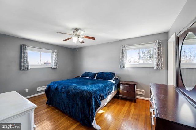 bedroom featuring a ceiling fan, light wood-style floors, and baseboards