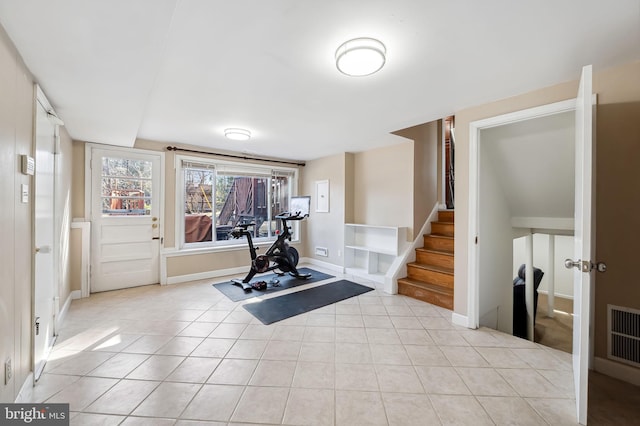 exercise area featuring light tile patterned floors, visible vents, and baseboards