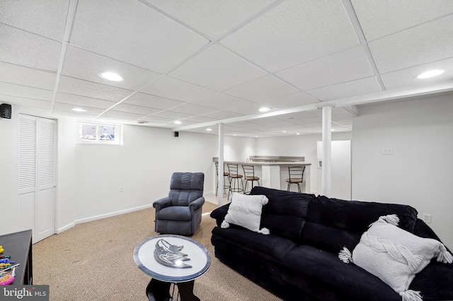 carpeted living room featuring recessed lighting, a paneled ceiling, and baseboards