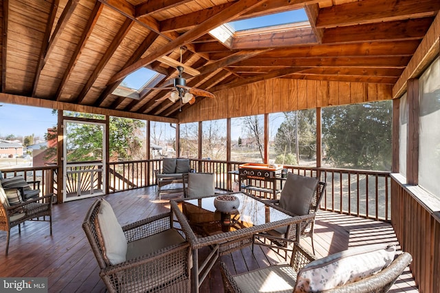 sunroom / solarium with vaulted ceiling with skylight and a ceiling fan