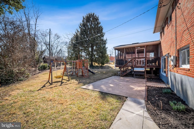 view of yard featuring stairs, a playground, a patio, and a sunroom