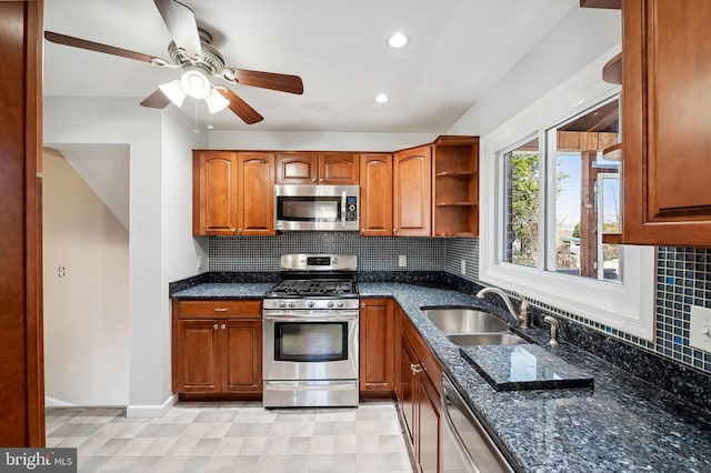 kitchen featuring decorative backsplash, dark stone countertops, appliances with stainless steel finishes, and a sink