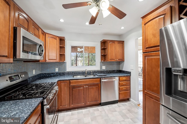 kitchen featuring open shelves, dark stone counters, a sink, stainless steel appliances, and brown cabinets