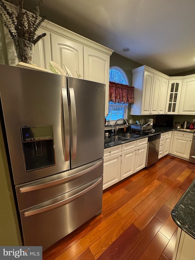 kitchen featuring white cabinetry, appliances with stainless steel finishes, sink, and dark stone countertops