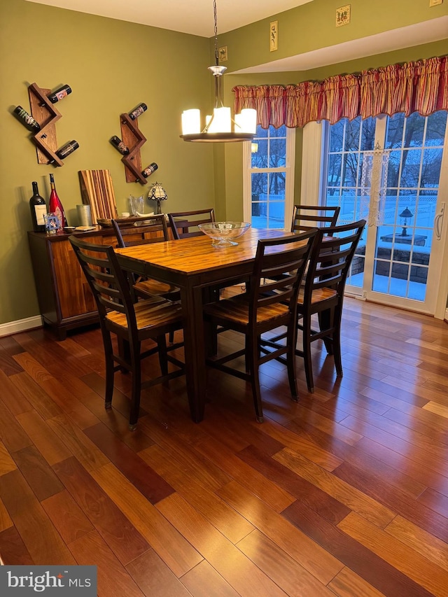 dining space featuring dark hardwood / wood-style floors and a chandelier