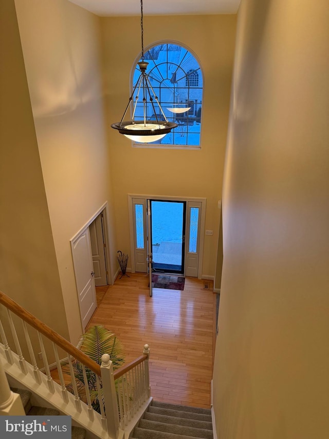 stairway featuring hardwood / wood-style floors and a towering ceiling