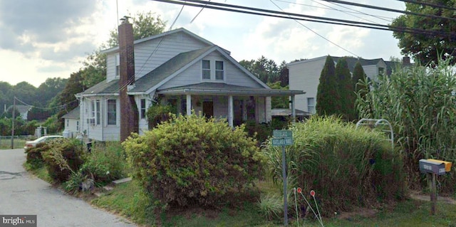 bungalow-style home with a porch and a chimney