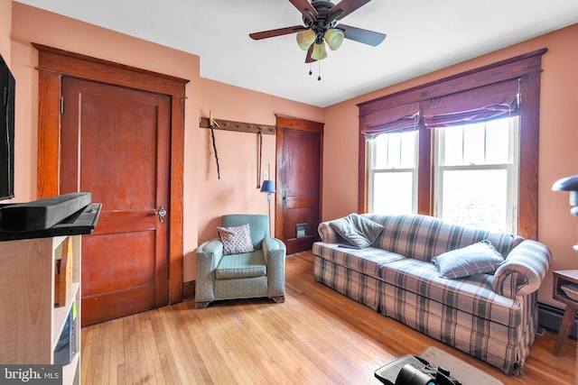 living area with a ceiling fan and light wood-type flooring