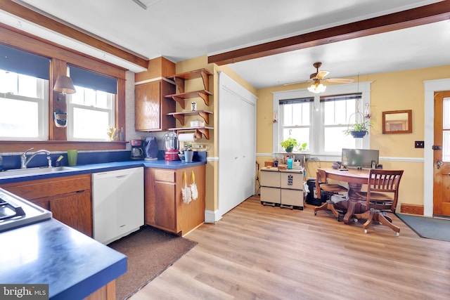 kitchen with white dishwasher, a sink, brown cabinets, ceiling fan, and light wood-style flooring
