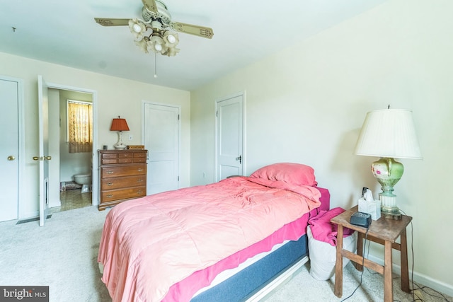carpeted bedroom featuring connected bathroom, baseboards, and a ceiling fan
