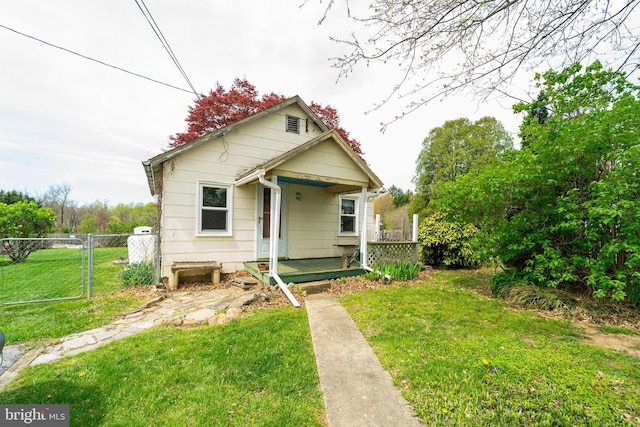 bungalow-style house with a gate, a front lawn, and fence