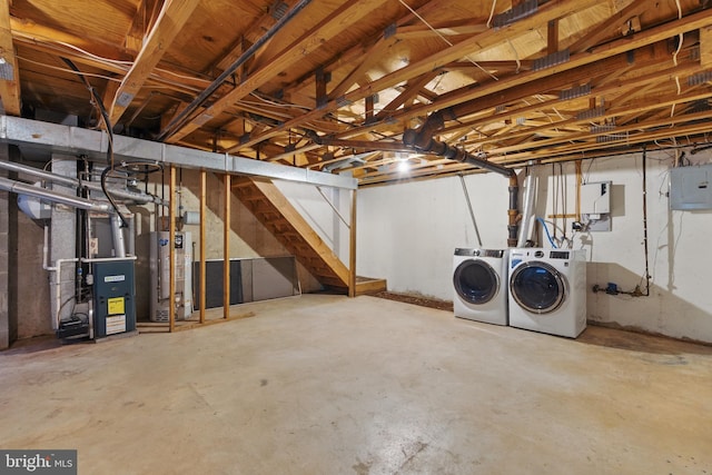 unfinished below grade area featuring electric panel, gas water heater, heating unit, and washing machine and clothes dryer