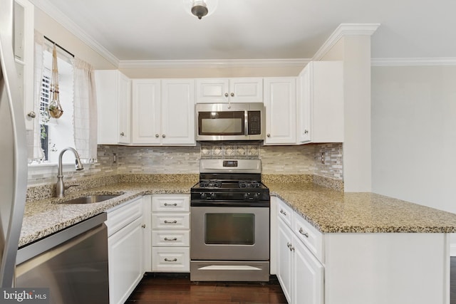 kitchen with a sink, dark wood-style floors, stainless steel appliances, a peninsula, and crown molding