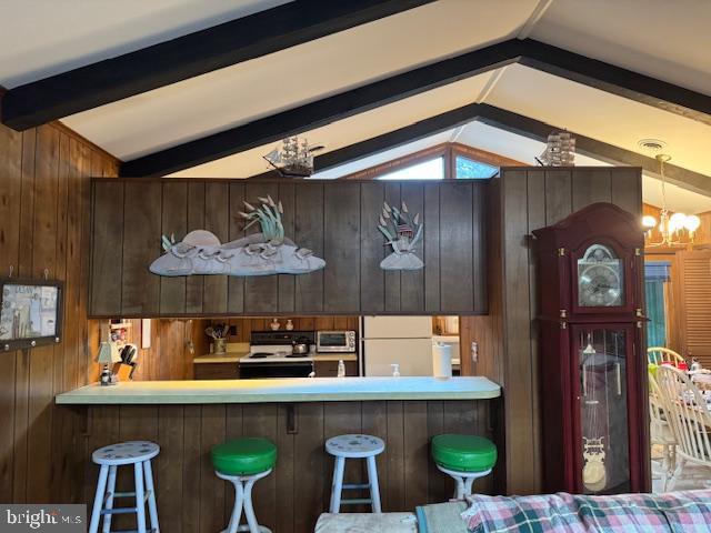 kitchen featuring wooden walls, lofted ceiling with beams, a kitchen breakfast bar, white fridge, and electric stove