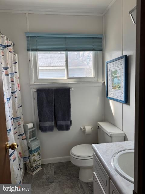 bathroom with vanity, crown molding, and toilet