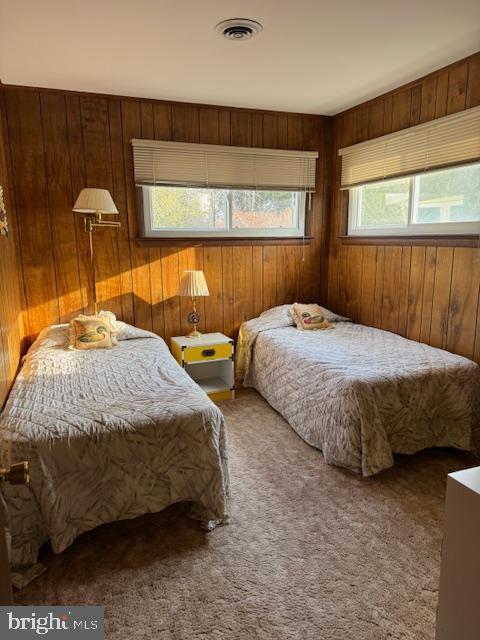 bedroom with wood walls and carpet