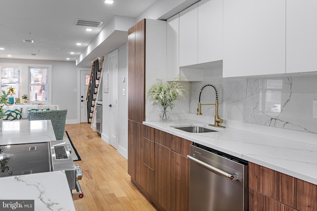 kitchen featuring white cabinetry, sink, light stone countertops, and dishwasher