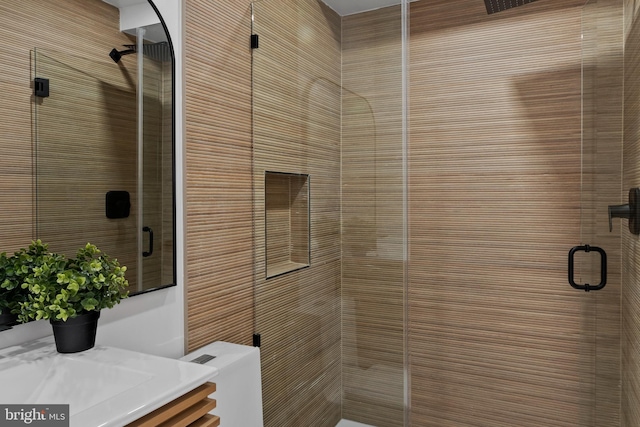 bathroom with vanity, a shower with door, and toilet