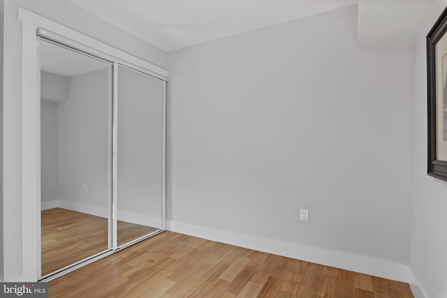 unfurnished bedroom with hardwood / wood-style flooring and a closet