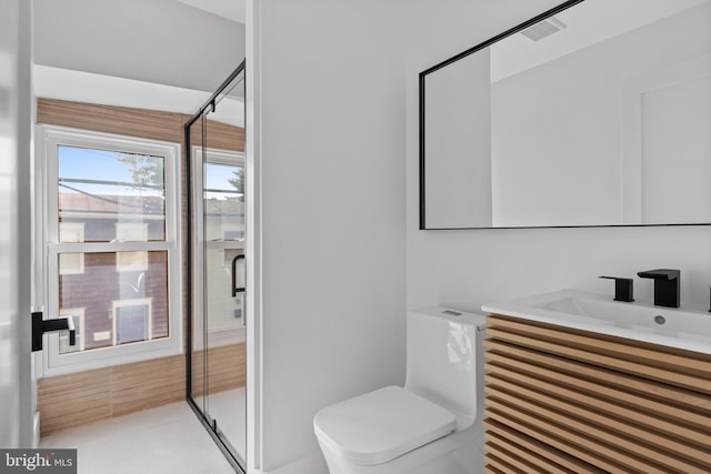 bathroom with a shower with door, vanity, and toilet