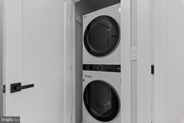 clothes washing area featuring stacked washer and clothes dryer