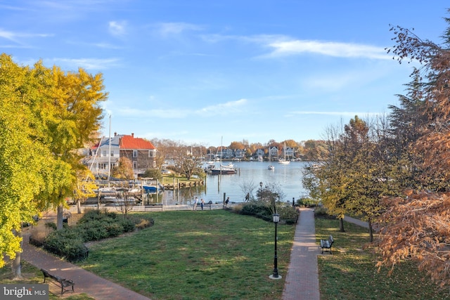 view of dock featuring a water view and a yard