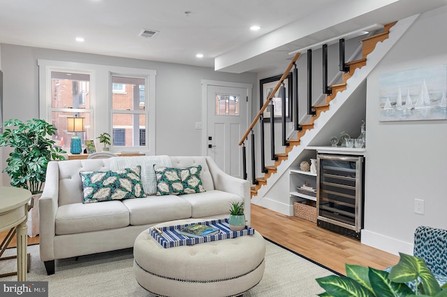 living room featuring hardwood / wood-style flooring, indoor bar, and beverage cooler