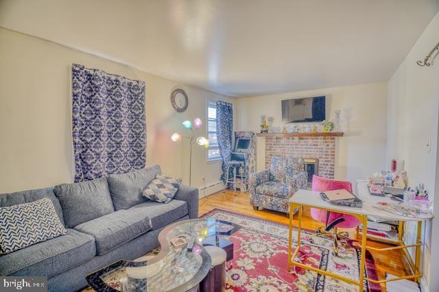 living area with a fireplace and wood finished floors