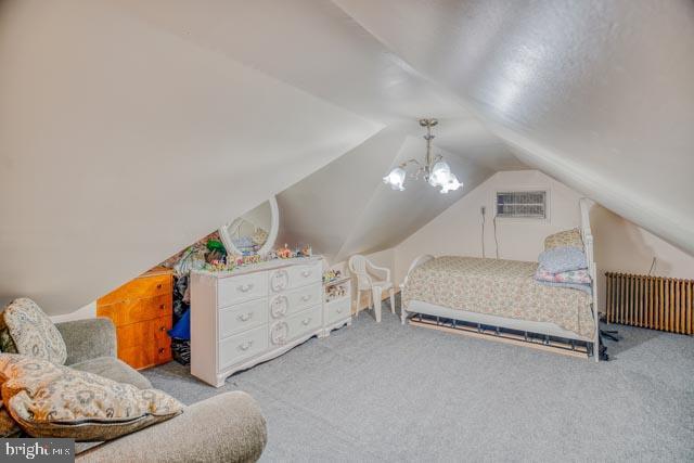 bedroom with radiator heating unit, carpet flooring, and a wall mounted AC