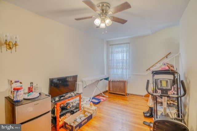 playroom with ceiling fan, radiator heating unit, and wood finished floors