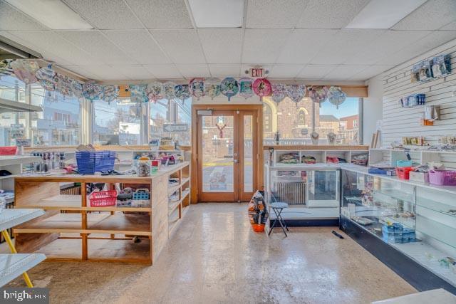 interior space featuring french doors and a drop ceiling