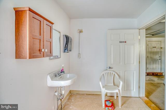 bathroom featuring baseboards and a sink