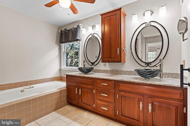 bathroom featuring vanity, tiled bath, and ceiling fan